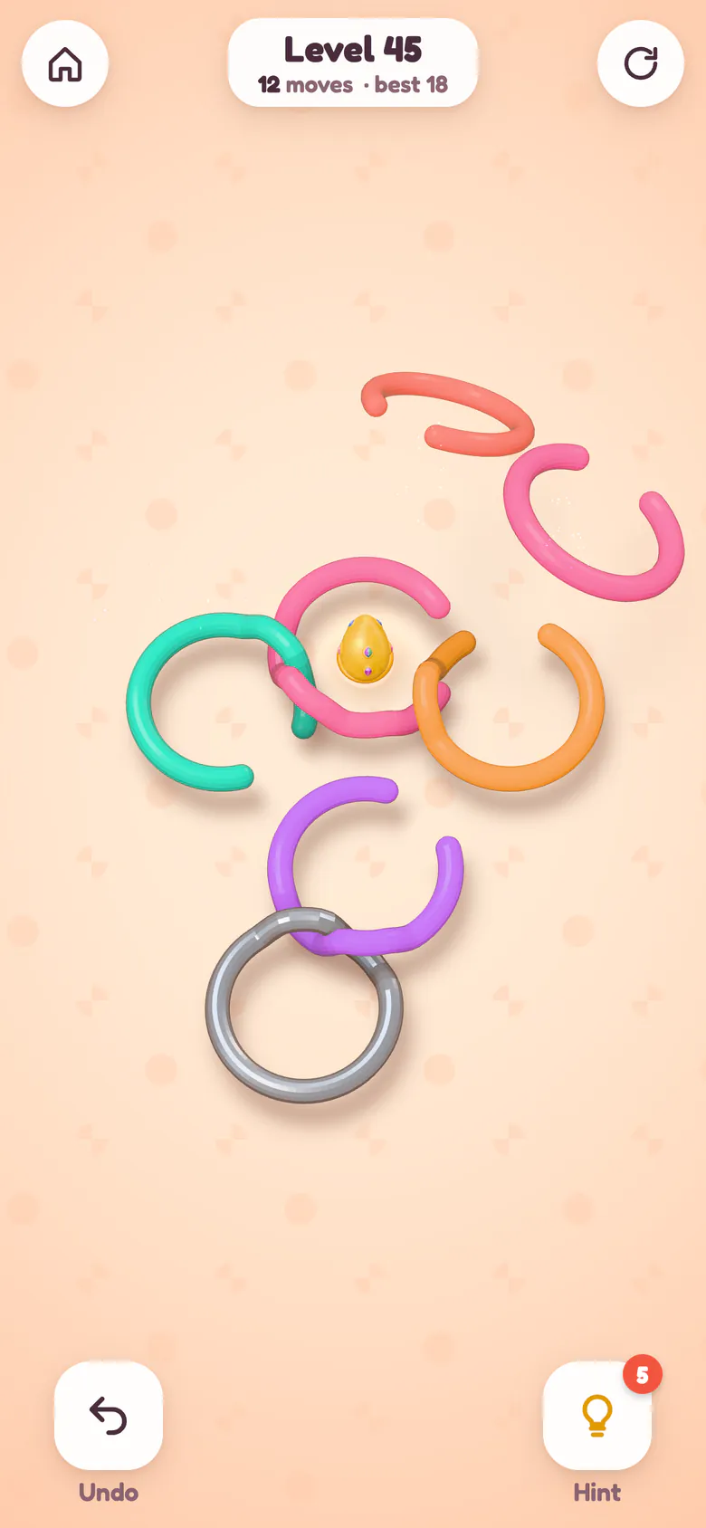 A pink ring flies off the cluster once its gap lines up, while the others stay linked.